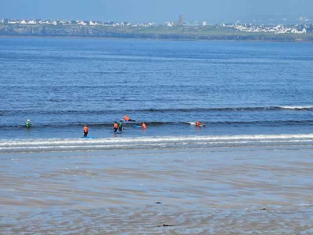 Beginner surfer paddling for a wave in the shallows
